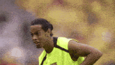 a soccer player wearing a yellow tank top with a fcb logo on it