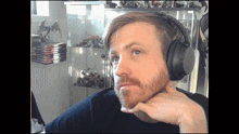 a man with a beard wearing headphones in front of a display case