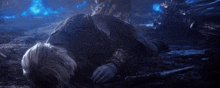 a person in armor is laying on the ground with a sword in their hand