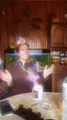 a woman wearing a party hat is sitting at a table