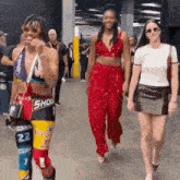a group of people are walking down a hallway and one of them is wearing a crop top with the number 22 on it .