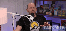 a man is sitting in front of a microphone with the words dark web on the bottom right