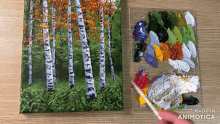 a painting of birch trees is being painted next to a palette