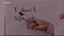 a man pointing at a white board that says " i don t speak french "