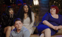 a group of people sitting on a couch with one woman looking surprised