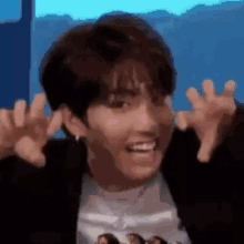 a close up of a person making a funny face with their arms outstretched .