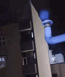 a blue pipe with a light on it is hanging from a building