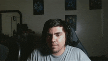 a man wearing headphones is sitting in front of a mirror with the number 10 on the wall behind him