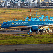 a blue vietnam airlines airplane is sitting on a runway
