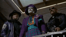 a man in a purple suit is standing next to a man in a black jacket