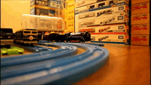 a stack of toy trains with boxes that say tomy on them