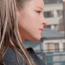 a close up of a woman 's face with a blue shirt on