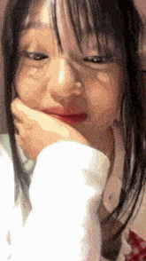 a close up of a woman 's face with her hand on her chin