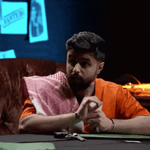 a man with a beard is sitting at a table with a car key on the table .