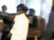 a blurry picture of a man in a white coat standing in a crowd of people .