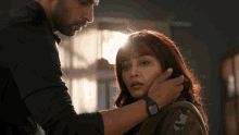 a man is touching a woman 's face while wearing a watch that says ' rolex ' on it
