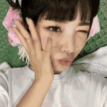 a woman laying on a green mat with a pink headband on her head