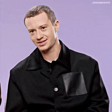 a man wearing a black jacket with a loewe pocket