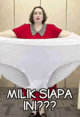 a woman in a red dress is holding a large white underwear .