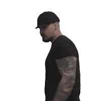 a man with a tattoo on his arm is holding a green x in his hand
