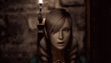 a person holding a candle in a dark room