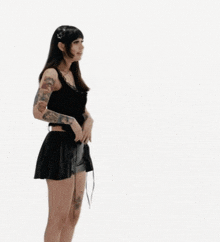 a woman in a black dress stands next to a cartoon dragon