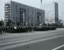 a black and white photo of a parade in front of a building