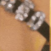 a person wearing a black bracelet with rhinestones and the number 50 on it