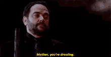 a man with a beard is standing in the dark and talking to someone .