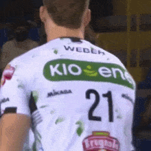 a man wearing a white and green shirt with the number 21 on it