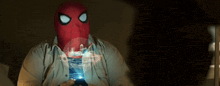a man wearing a spiderman mask is looking at a phone