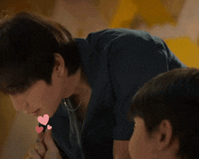 a man is kissing another man 's hand with hearts on it