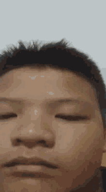 a close up of a man 's face with his eyes closed .