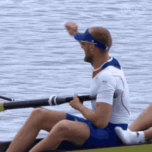 a man in a white shirt is rowing a boat