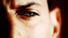 a close up of a man 's eye with a green eye