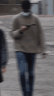 a blurry picture of a man wearing a mask walking down a street