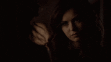 a woman in a dark room with the words indulge me below her