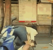 a man sits on a motorcycle in front of a sign that says ' menu ' on it