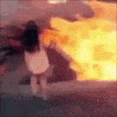 a blurry picture of a girl standing in front of a fire .