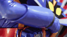 a close up of a blue superhero 's arm with a red belt