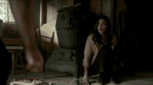 a woman is tied to a man 's leg in a dark room