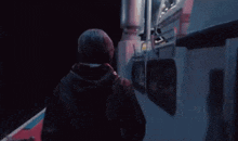a man is standing on the side of a boat looking out the window .