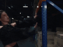 a woman in a black crop top is dancing in a warehouse