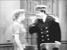 a black and white photo of a man and woman talking to each other