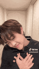 a young man in a black shirt has a tiktok sticker on his shirt