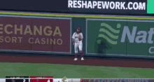 a baseball player stands in front of an advertisement for reshapework