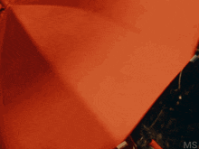 a close up of a woman wearing a red hooded jacket with the letters ms on the bottom right