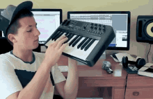 a young man playing a keyboard in front of a computer monitor