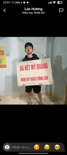 a young man is holding a sign that says da het my quang