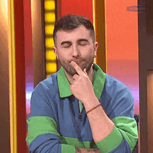a man with a nose ring is thinking with his eyes closed .